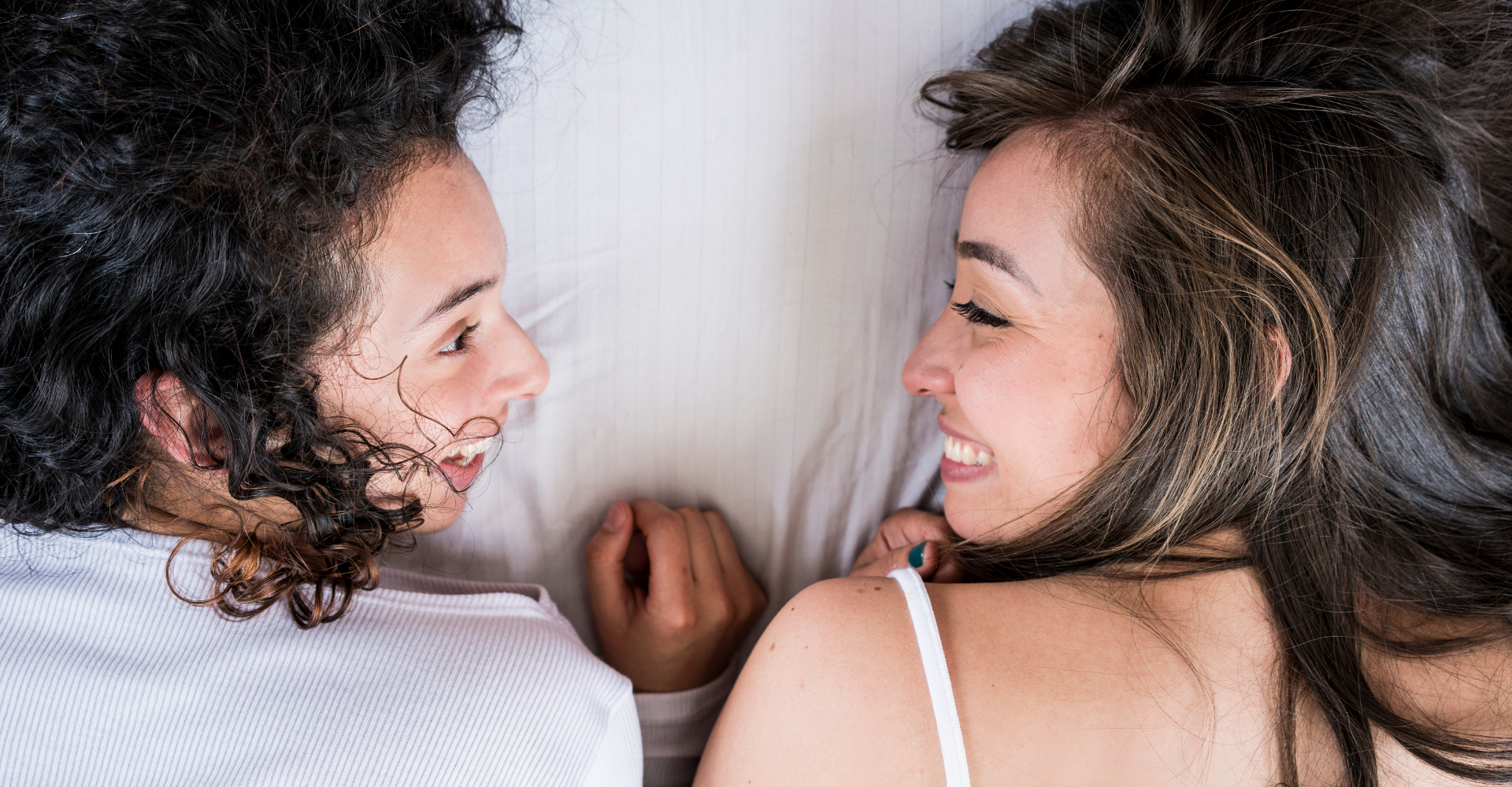 two women cuddling in bed